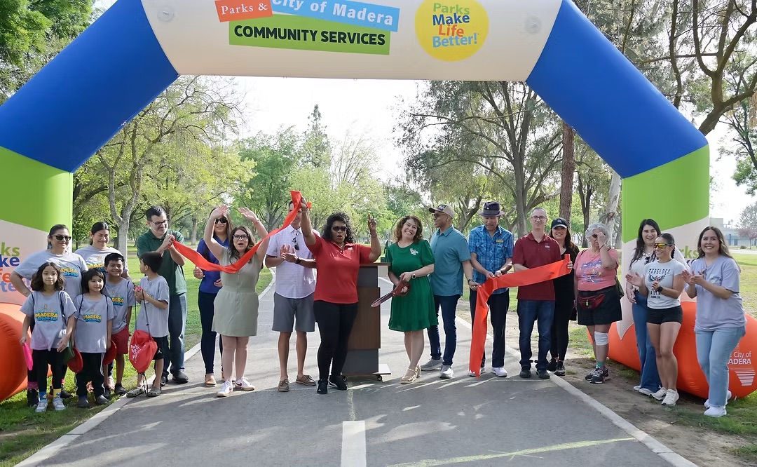 Dignitaries and community members gather at Town and Country Park to cut a ribbon for the new trail system
