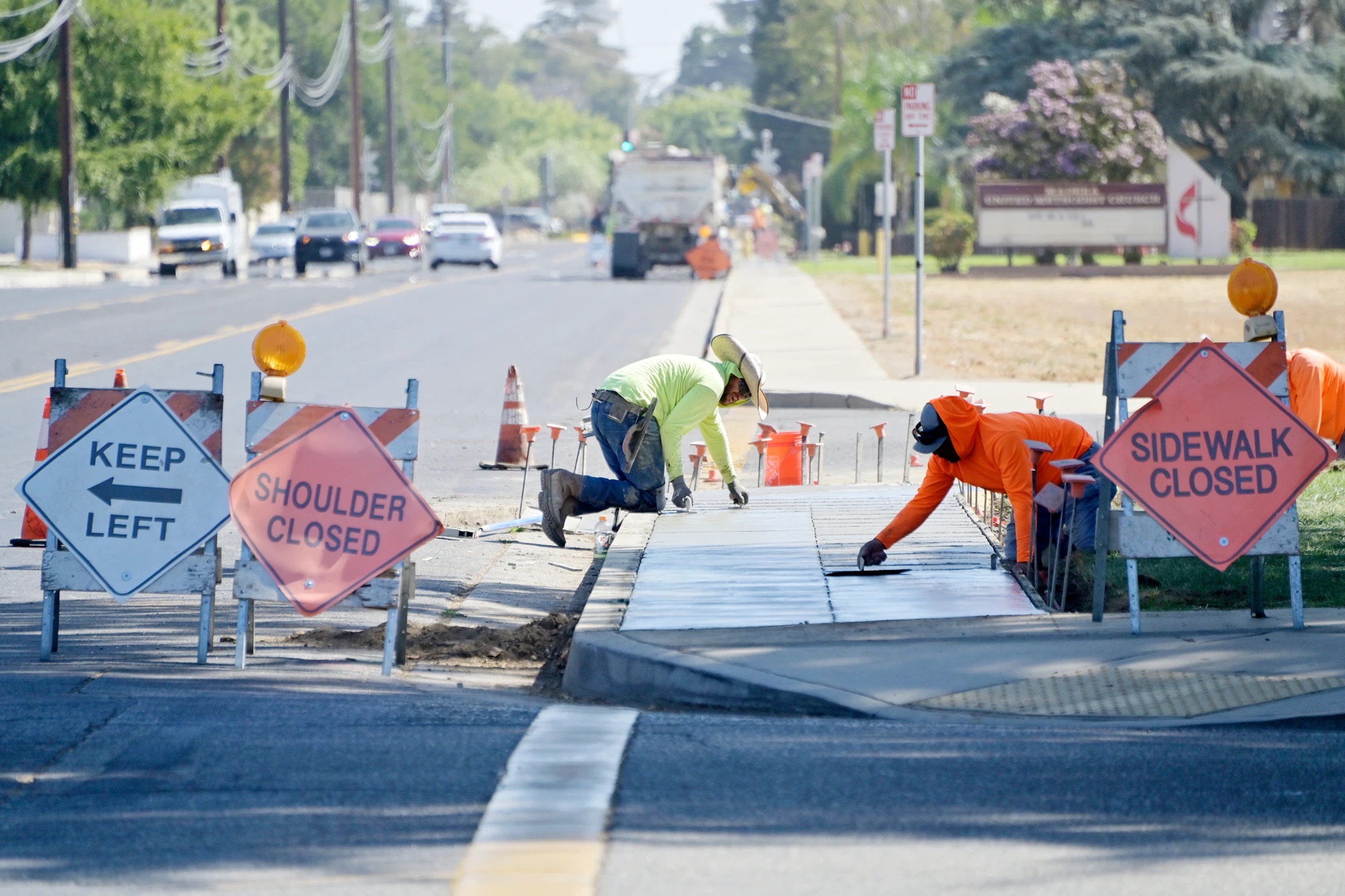 Contractors work on installing new sidewalks on Sunset Ave