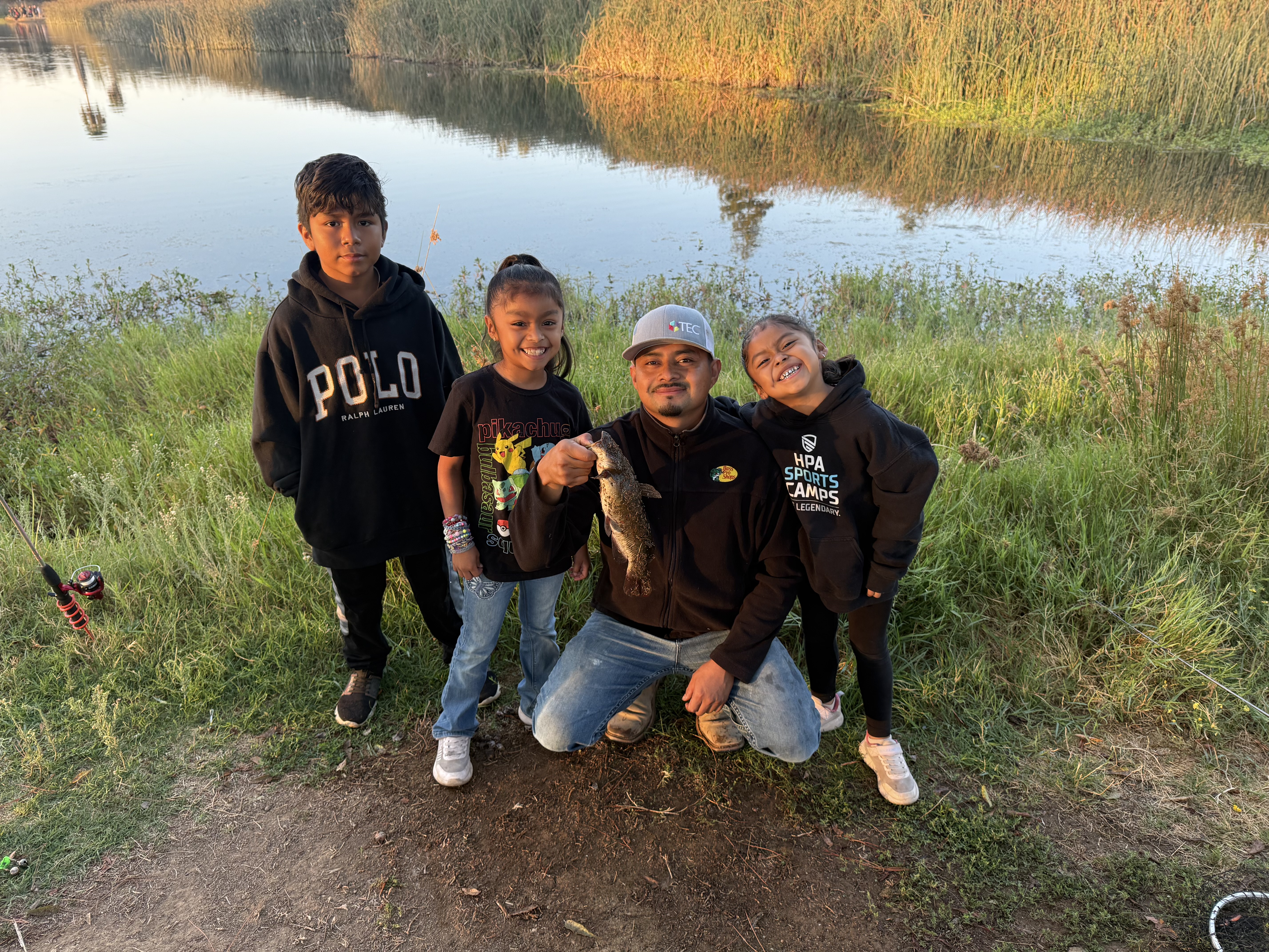 A family presents a fish caught during the fishing derby